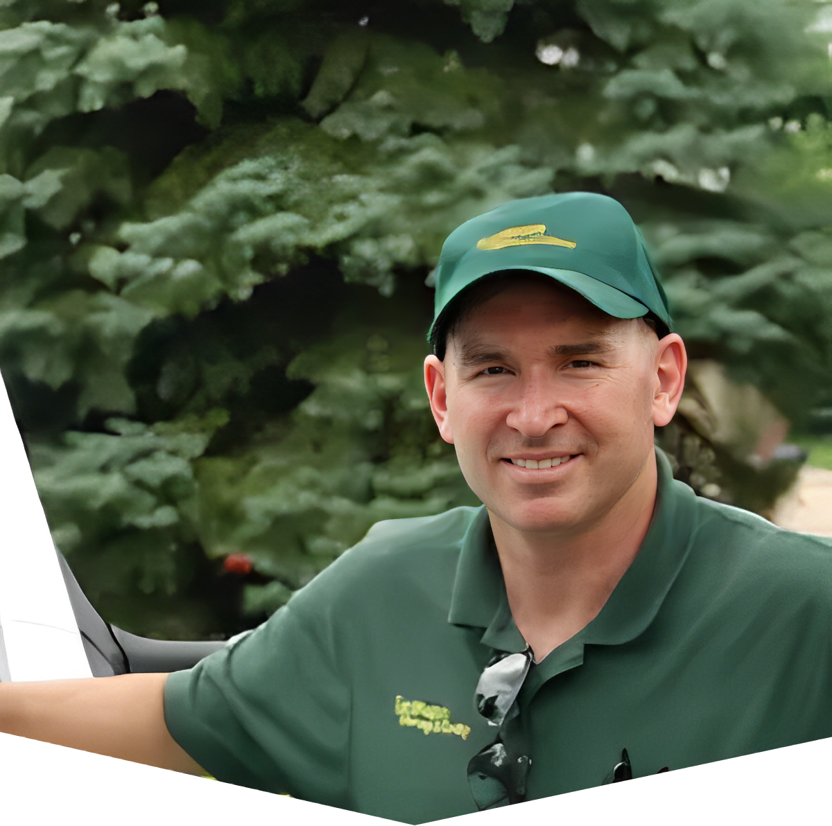 A man in green shirt and hat smiling for the camera.
