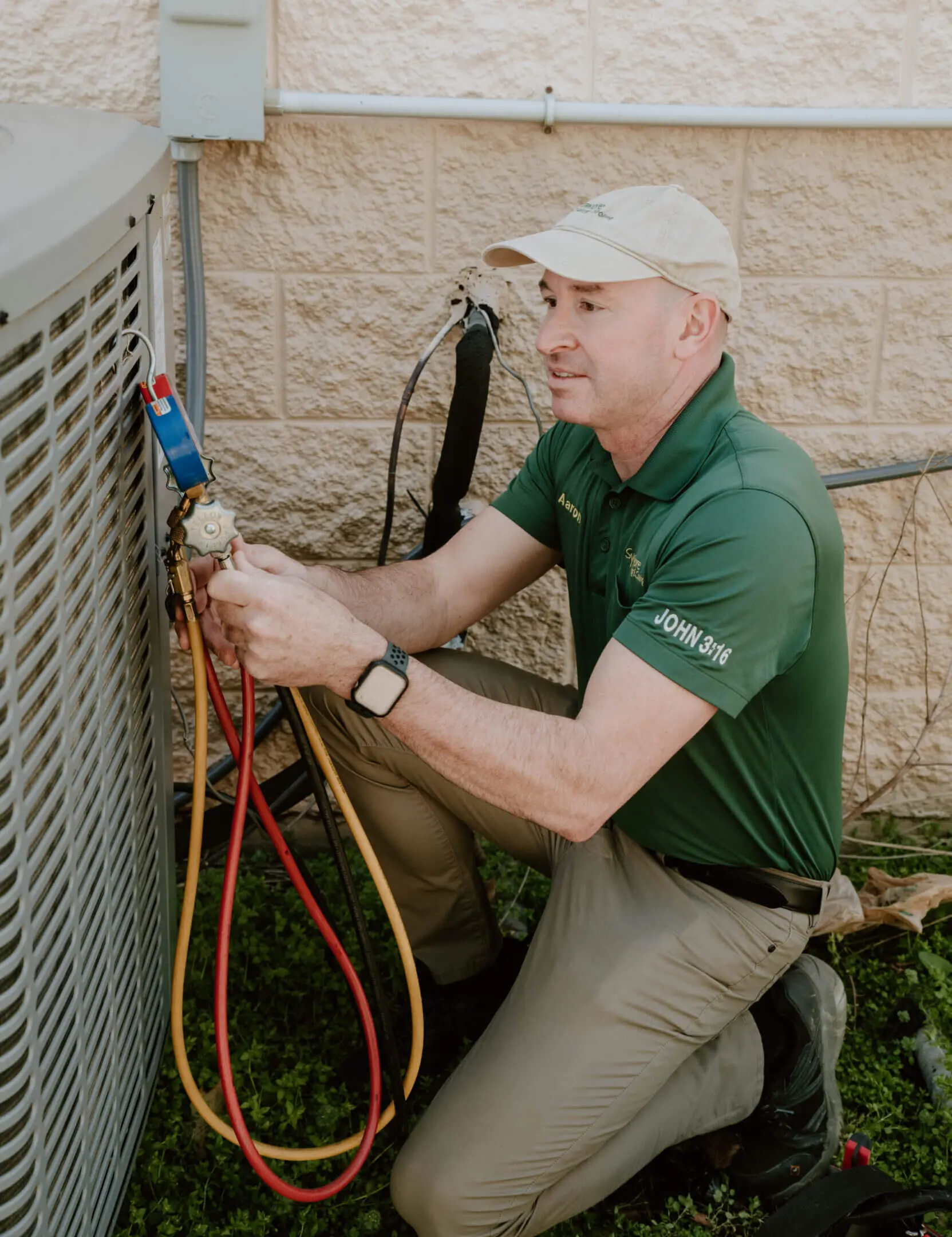 A man in green shirt fixing air conditioner.