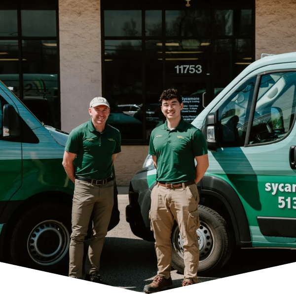 Two men standing in front of a truck.